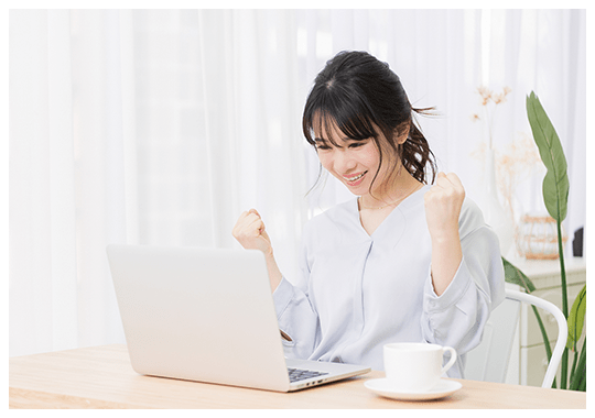 女性がパソコンを見て喜んでいる様子
